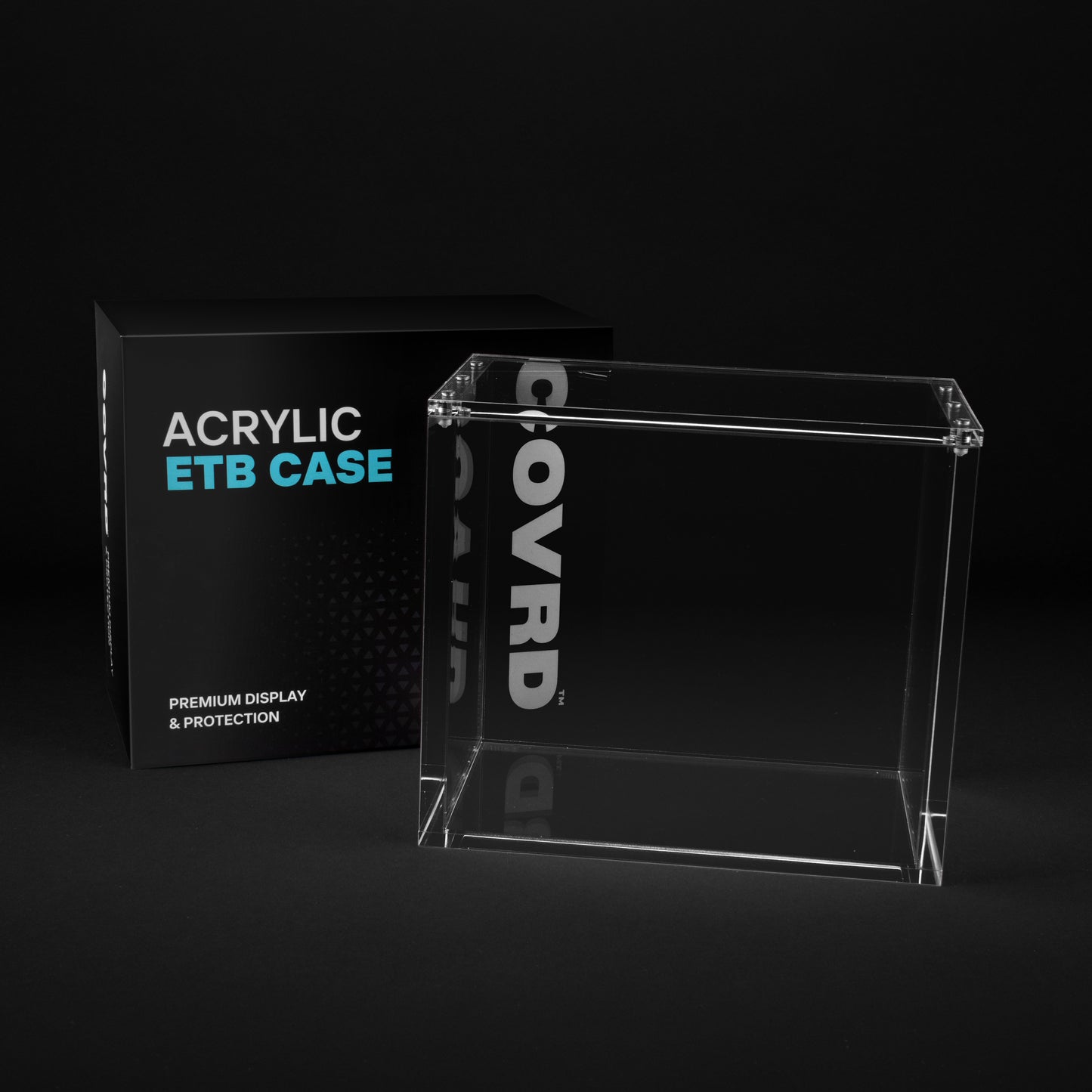 Clear COVRD acrylic ETB display case next to its black product packaging.