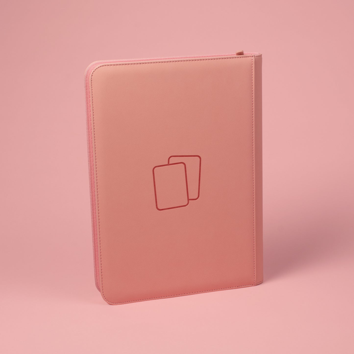 Back view of blush pink COVRD card album standing upright showing the debossed logo asset.