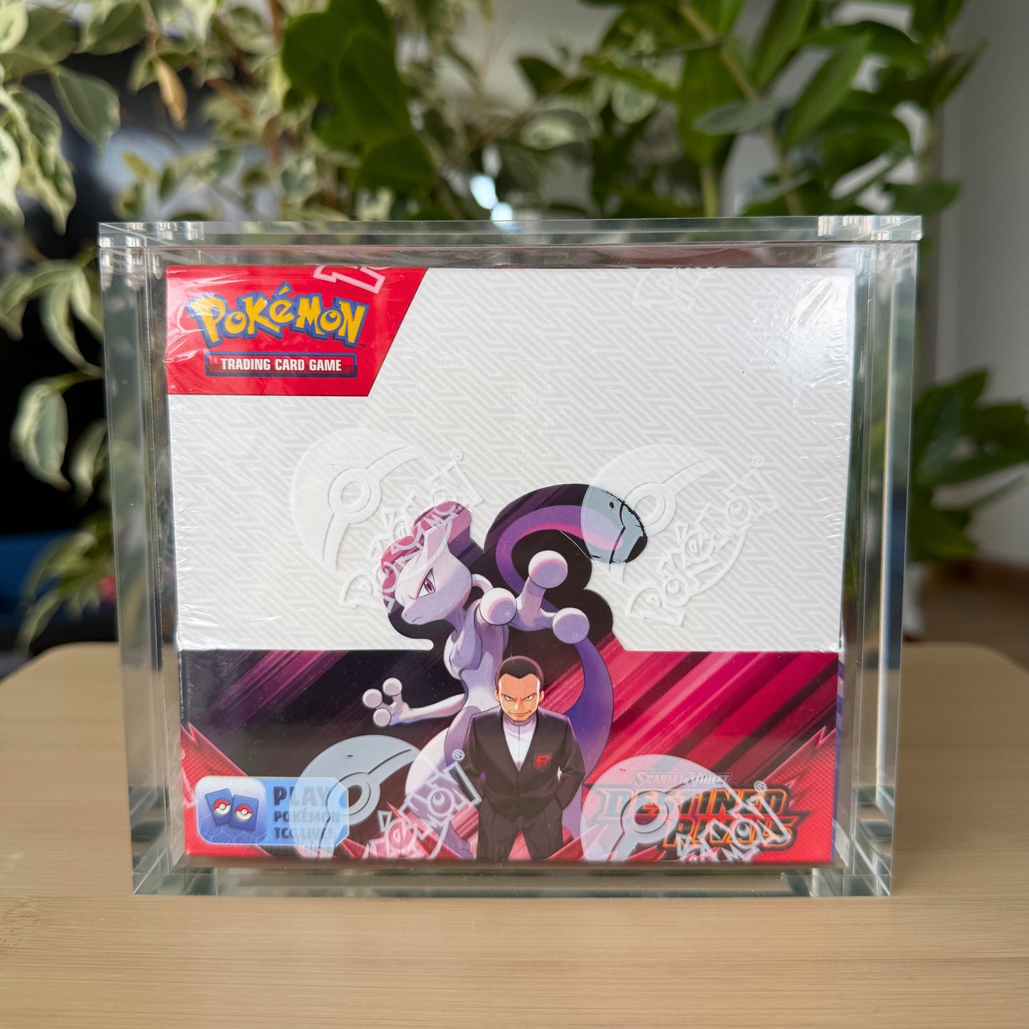 A sealed Pokémon booster box displayed inside a COVRD clear acrylic protective case.